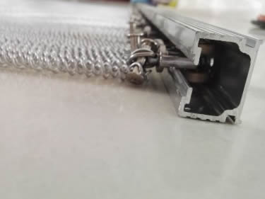 A metal coil drapery with track on the desk.