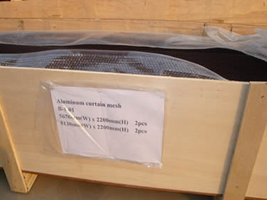 Metal coil drapery is placed in the wooden carton.