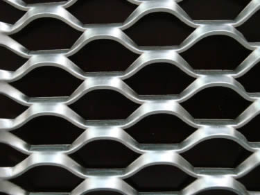 An aluminum expanded metal sheet on the black background.