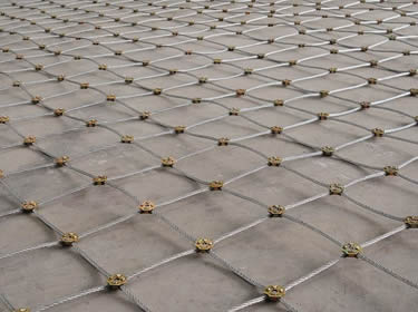 A piece of square rope mesh with cross clamps on the ground