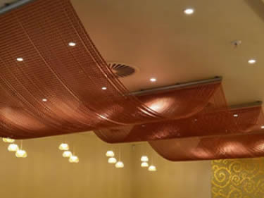 The copper chain link curtain is installed on the ceiling for decoration.