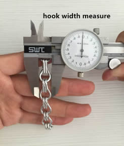 A hand is holding the chain link curtain and the other hand is measuring the hook width by vernier caliper.