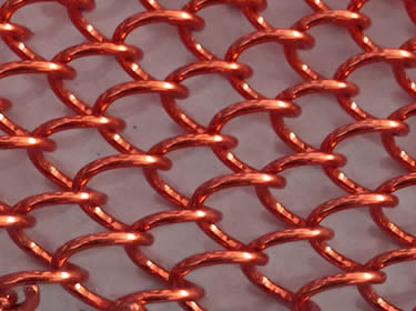 A piece of coil drapery mesh in dark red color