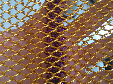 Golden coil drapery and purple coil drapery on a hand