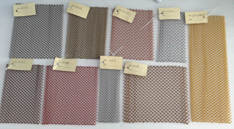 Neun Metallspulen-Vorhänge in neun Farben auf dem Schreibtisch.