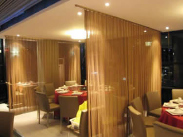 Brass metal coil draperies are installed in the restaurant for divider.