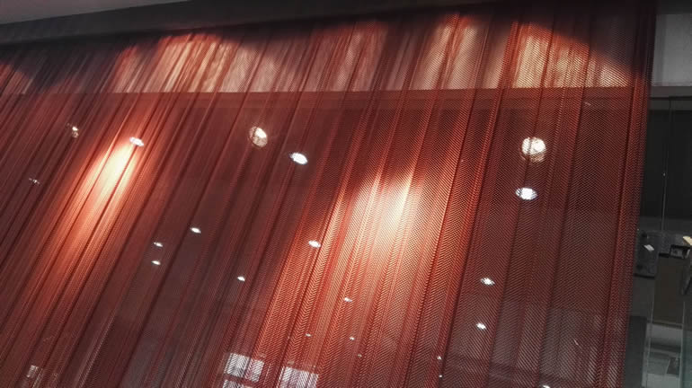 牆上掛著一個深紅色的線圈窗簾。 從線圈窗簾中穿透,您可以看到美麗的白光。
